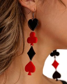 a woman wearing red and black earrings with playing cards dangling from it's ear