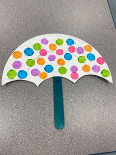 an umbrella made out of paper and colored dots