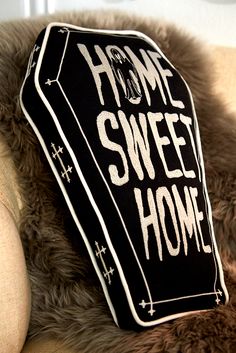 a teddy bear with a sign on it's back that says home sweet home