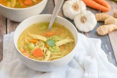 two bowls of soup with carrots, celery and ginger on the side