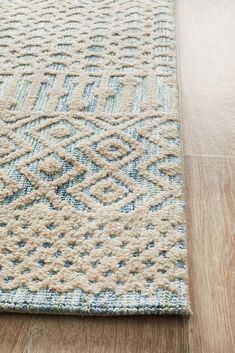 a blue and white rug on the floor with wood floors in front of it,