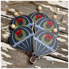 three hot air balloons with bows on them are sitting on a wooden table and one is hanging from a string