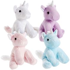 three stuffed unicorns are sitting side by side