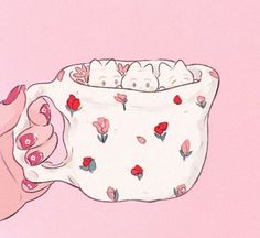 a hand holding a cup with flowers on it