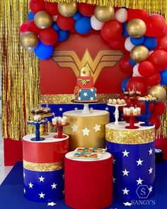 a table topped with red, white and blue desserts next to an american flag arch