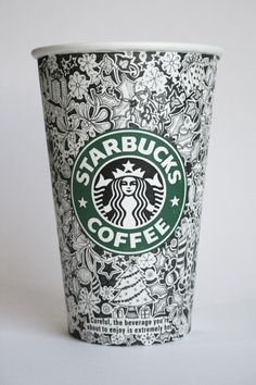 the starbucks coffee cup is decorated with black and white designs on it's side