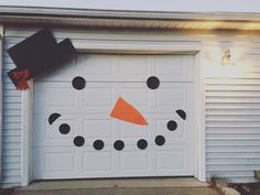 a white garage door decorated with a snowman's face and black polka dots