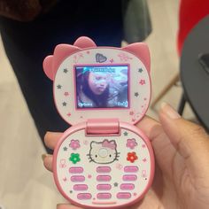 a hello kitty cell phone is being held up