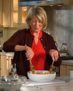 a woman is preparing a bowl of food in the kitchen