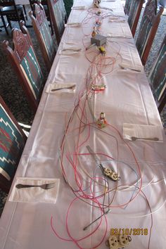 a long table with many wires on top of it and some chairs around the table