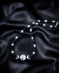 In honour of Artemis, Goddess of the wilds and Goddess of the moon. She who wears the crescent moon crown. An enchanting beaded strand featuring a Selenite sphere framed by crescent moons, and strung between black Onyx and silver freshwater pearls. This necklace depicts the Triple Goddess symbol,  the Selenite bead in the centre symbolising the full moon with a waxing and waning crescent on either side.  The crescent moon beads are produced in sterling silver and are uniquely textured by hand gi Bohemian Jewelry With Moon Charm And Round Beads, Bohemian Beaded Crescent Jewelry, Bohemian Crescent Beaded Jewelry, Spiritual Crescent Moon Phase Crystal Necklace, Mystical Moon-shaped Adjustable Necklace, Adjustable Mystical Moon Necklace, Festival Jewelry With Moon Charm And Round Beads, Mystical Adjustable Necklace With Round Beads, Adjustable Mystical Necklace With Round Beads