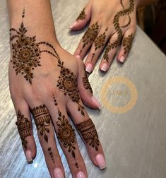 two hands with henna designs on them