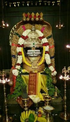 the statue is decorated with flowers and other things in front of it, including bananas