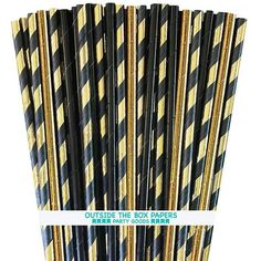 black and gold striped paper straws are stacked on top of each other, with the words outside the box papers