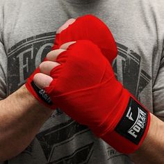 a man wearing red boxing gloves with his hands wrapped around the wrist and fist bump