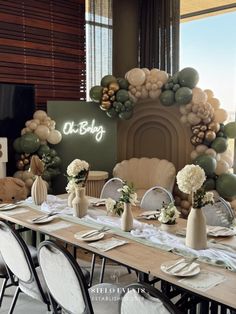 a table set up for a party with balloons and flowers