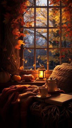 an open book and cup on a table in front of a window with autumn leaves