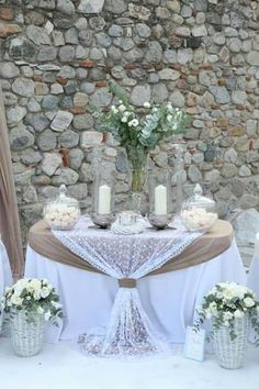 the table is set with white flowers and candles