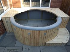 an outdoor hot tub built into the side of a brick building with doors and windows