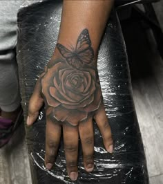 a woman's hand with a tattoo on it and a butterfly on the wrist