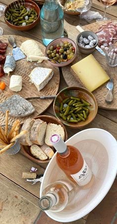 a wooden table topped with plates and bowls filled with different types of food on top of it