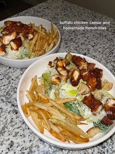 two white plates filled with food sitting on top of a marble counter next to each other