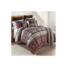 a bed with plaid comforter and pillows