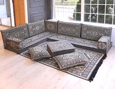 a living room filled with lots of furniture on top of a hard wood floor next to a window