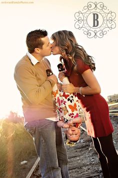 a man and woman kissing in front of the camera