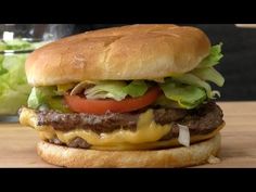 a cheeseburger with lettuce, tomato and onion