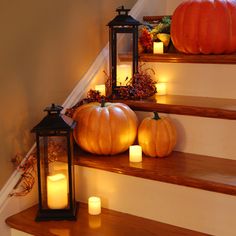 some pumpkins and candles are sitting on the stairs