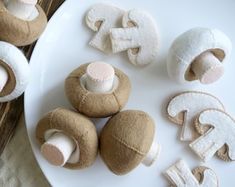 several different types of stuffed animals on a white plate next to some cookies and doughnuts