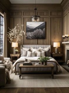 a bedroom with wood paneled walls and white bedding, two couches, a coffee table, and a painting on the wall