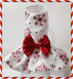 a white dress with red bows and snowflakes on the collar is shown in front of a white background