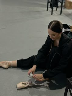 a woman is sitting on the floor with her shoes off