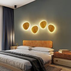 a large bed sitting in a bedroom next to a wall with three lights on it