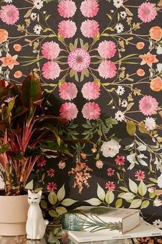 a vase with flowers on top of a table next to a wallpapered wall