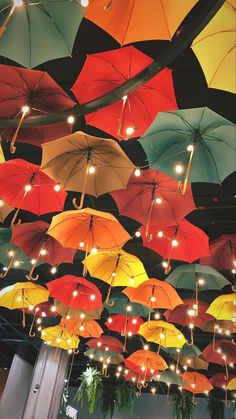 many colorful umbrellas are hanging from the ceiling