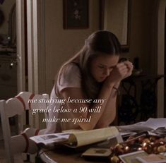 a woman sitting at a table in front of a plate of food with the words, not studying because any grade below her