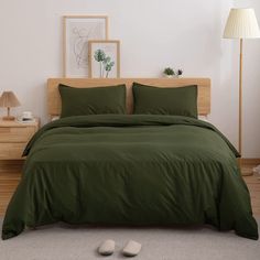 a bed with green sheets and pillows in a room