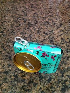 an open can of soda sitting on top of a counter next to a pair of scissors