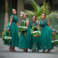 four beautiful women in green dresses holding flowers