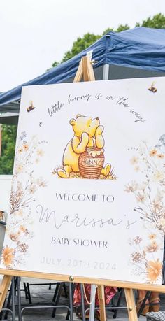 a welcome sign for a baby shower with winnie the pooh and honey pot on it