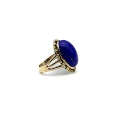 This is part of Chairish’s Fine Jewelry assortment.  A vivid blue lapis cabochon is bezel set into a halo of 22k gold nuggets. The stone is a deep, well-saturated cobalt blue, while the gold nuggets bring richness and texture to the surface of the ring. The effect is stunning, and the two elements compliment each other beautifully. The 14k gold band splits into three, adding a hint of drama and elegantly framing the lapis centrepiece. A bold cocktail ring, true blue!  This type of nugget work ar