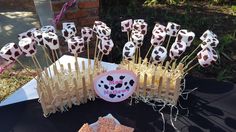 a table topped with marshmallows and cow print lollipop sticks