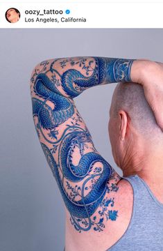 the back of a man's head with tattoos on his arms and shoulder, in front of a gray background