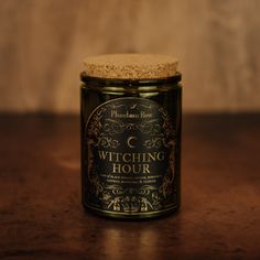 a glass jar with a cork lid sitting on top of a wooden table next to a wall