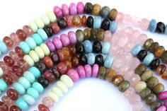 multicolored beads are lined up on a white surface