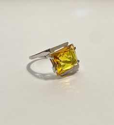 This Vintage 10k White Gold Yellow Sapphire Ring is magnificent! The ring showcases a Emerald set in a four prong setting The Sapphire stone has beautiful color. The stone measures approximately 10mm x 12mm = 6.84 carats The setting is beautiful with a unique style The ring is marked U - 10k Weight- 3.61g Size-7 Formal Yellow Solitaire Jewelry, Classic Yellow Topaz Ring With Emerald Cut, Classic Emerald Cut Yellow Topaz Ring, Classic Yellow Emerald Cut Topaz Ring, Classic Yellow Topaz Ring With Center Stone, Yellow Emerald-cut Diamond Ring With Prong Setting, Yellow Solitaire Topaz Ring, Yellow Topaz Solitaire Ring, Fine Jewelry Yellow Rings With 17 Jewels