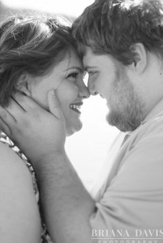 black and white photograph of a man and woman smiling at each other with their faces close together